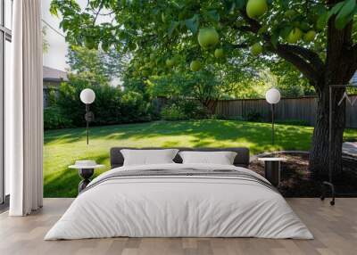 A serene backyard with a tree bearing green fruit and lush grass. Wall mural