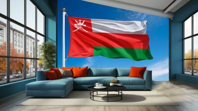 Oman flag waving in the wind against a blue sky background Wall mural