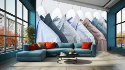 Assorted blue shirts hanging on wooden hangers Wall mural