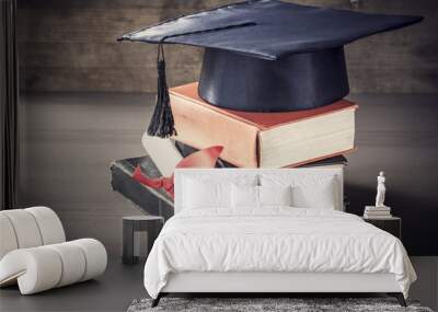 Graduation hat and diploma with book on table Wall mural