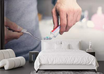 Hand extrude a toothpaste from a tube on a toothbrush Wall mural