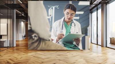 Health worker taking notes from male patient Wall mural