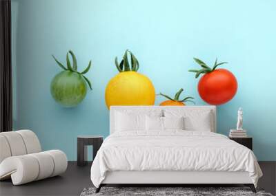 Colorful organic cherry tomatoes on a blue background, creative flat lay healthy food concept, top view Wall mural