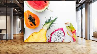 Flat lay tropical fruit layout made of dragon fruit, watermelon, papaya and pineapple on a white background, creative summer food concept Wall mural