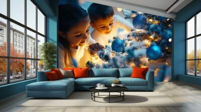 Children playing near a snowy Christmas tree with blue and silver decorations, the room glowing with festive lights. Wall mural