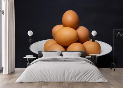 White plate with arrangement of raw chicken eggs. Raw chicken eggs for cooking purposes. Wall mural