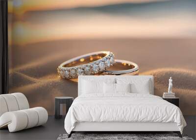 A promise whispered on the shore. Two glistening diamond wedding rings rest delicately upon a bed of coarse, cooling sand granules.  Wall mural