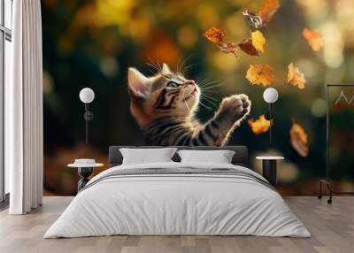 Capture the Playful Moment of a Kitten with Falling Leaves in an Autumn Setting Wall mural