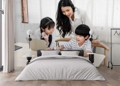 Asian mother are looking care her son and daughter, they are do their homework the mother teach them. Happy family, kids caring, education study and motherhood concept. Wall mural