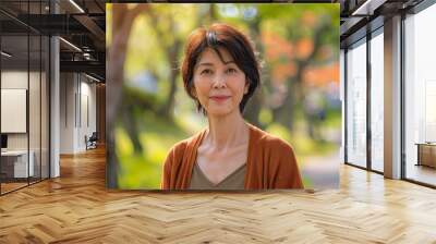 Portrait of a mid aged Japanese short haired woman on spring outdoors park background with copy space Wall mural