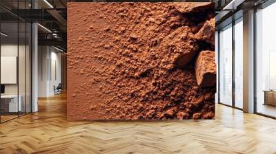 Rich cocoa powder and chunks of dark chocolate on a textured brown surface. Wall mural