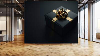 A black gift box representing a luxury gift with a golden band on a black background. Wall mural