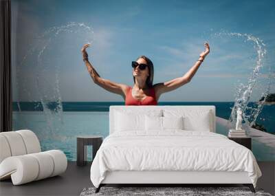 Young beautiful woman splashing water in swimming pool  Beautiful seascape. Trip to warm destination. Phuket. Thailand. Wall mural