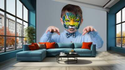 little boy painted like a tiger on a gray background. face painting Wall mural