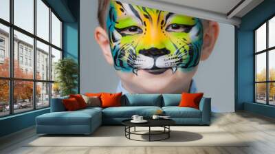 little boy painted like a tiger on a gray background. face painting Wall mural