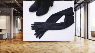 Gloves and autumn boots made of genuine black suede leather on a white wooden background Wall mural