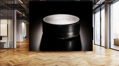 An illuminated hockey puck on a black background Wall mural