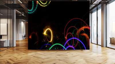 Bright rounded glowing splashes on black backdrop with copy space. Wall mural