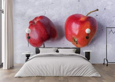 Close-up two ugly red apples on grey concrete background.  Wall mural