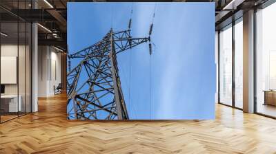 Tower of high voltage transmission stands tall against blue sky with clouds. Banner. Copy space. Wall mural