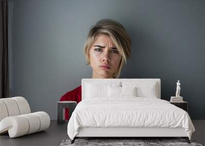 Portrait of a sad or unhappy or upset woman isolated on gray background Wall mural