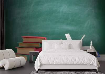 Education and reading concept - group of colorful books on the wooden table in the classroom, blackboard background Wall mural