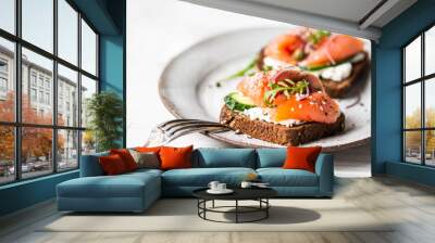 Healthy toasts with rye bread with cream cheese, salmon, fresh cucumber, capers, sesame seeds, black pepper and arugula Wall mural