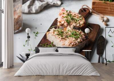 Healthy toasts with salmon pate and fresh green sprouts on yeast-free bread on wood cutting board on grey background. Copy space Wall mural