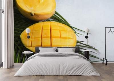 Ripe yellow mango slice on palm tree leaves on gray background. copy space Wall mural