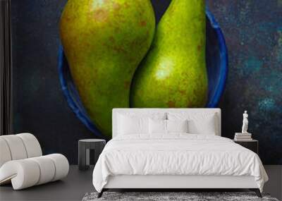 Two ripe yellow green pears in a blue bowl on a dark vintage background

 Wall mural