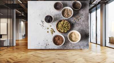 Various seeds - sesames, flax seed, sunflower seeds, pumpkin seed, poppy, chia in bowls on a gray background. Copy space. top view Wall mural