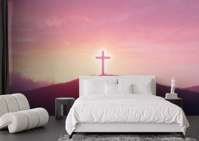 Silhouette of a cross on a hilltop at sunset. Wall mural