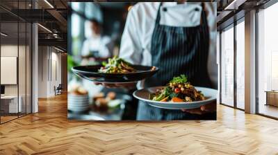 Close-up of two plates of food placed on both hands of the chef in the hotel kitchen. Wall mural