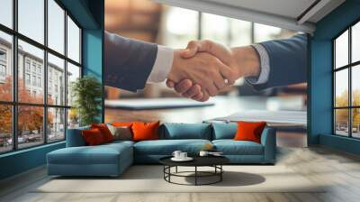 A pair of business partners sitting in a quiet office, signing a partnership agreement, with documents neatly arranged on the table and a handshake sealing the deal Wall mural