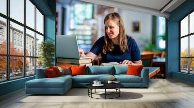 A visually impaired woman sitting and studying in the university library Wall mural