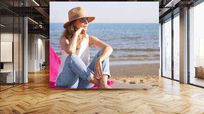 Ejoying summer on seaside. Beautiful woman relaxing on the beach. Wall mural