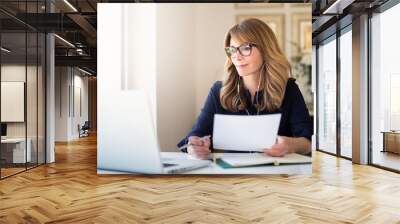 Smiling businesswoman having web conference while working from home Wall mural