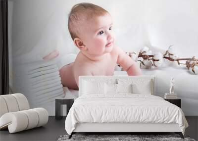 Baby in diaper on a white background with a branch of cotton Wall mural