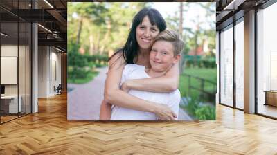 horizontal closeup portrait of a thirty year old woman with her teenage son in a summer park Wall mural