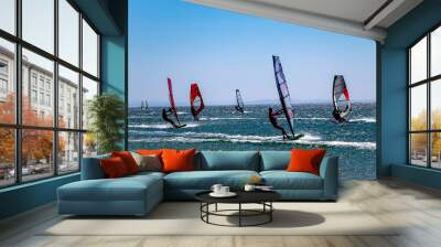 Kefalos beach, Gokceada, Turkey - 21-08-2021 colorful windsurfers on a windy day. Practicing wind surfing. People are engaged in sailing, windsurfing. Wall mural