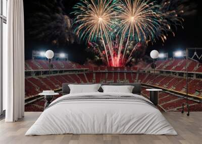 Spectacular fireworks display lights up the night sky above a large stadium Wall mural