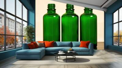 Three empty green glass bottles for women's cosmetics spray. Traditional cosmetics and healthcare Wall mural