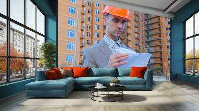 portrait of construction specialist in helmet and suit against building	 Wall mural