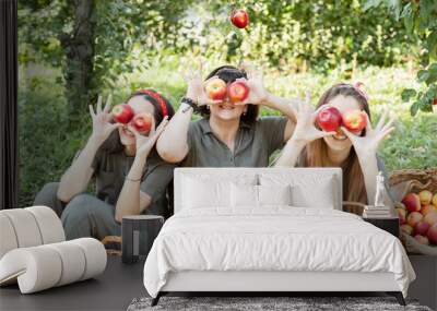 Girls with Apple in the Apple Orchard. Beautiful sisters with Organic Apple in the Orchard. Harvest Concept. Garden, teenagers eating fruits at fall harvest. Wall mural