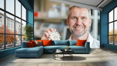 A man smiles while holding a 3D printed model. AI. Wall mural