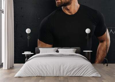 Bearded handsome man in black shirt and white boxers at black background. Sexy muscled guy in casual underwear in studio. Male fitness model posing in relaxing outfit. Wall mural