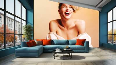 Curly wide smiling female model with retro hair style and dressed in white fancy dress Wall mural