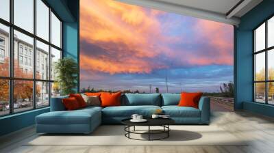 A highway with a beautiful orange sky in the background Wall mural