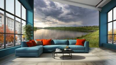 A lake with a cloudy sky in the background Wall mural