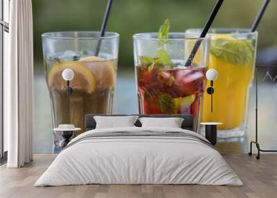 Three glasses of different colored drinks with straws in them Wall mural